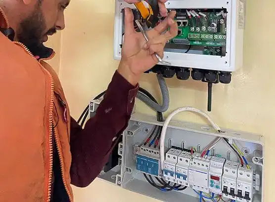 An engineer is installing a solar combiner box