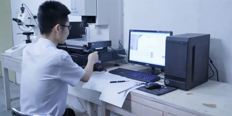 Technician using optical measurement equipment at a dimensional-inspection workstation